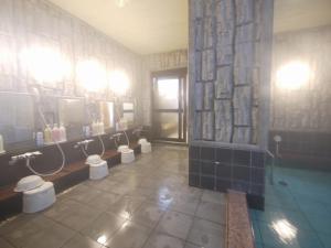 横手市横手因特路线酒店的浴室设有4个小便池、水槽和镜子