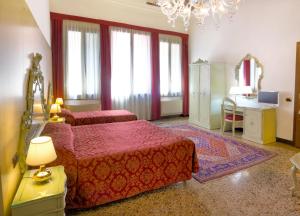 威尼斯Guesthouse Ca' San Marcuola 1的一间卧室配有两张床和一张桌子及一张桌子。
