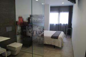 菲格拉斯Hostal Sanmar的浴室设有1张床和带卫生间的淋浴。