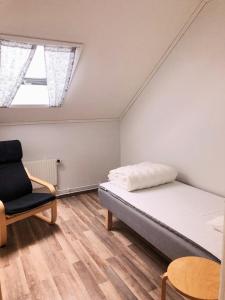 特鲁萨Trosa Vandrarhem的一间卧室配有一张床和一把椅子