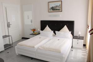 威斯巴登阿姆舒洛斯布里希酒店的卧室配有白色大床和白色枕头