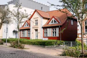 施特拉尔松德伽格菲斯汀格酒店的一座有红色屋顶的房子,前面有一辆自行车