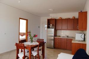 马拉松坎博斯Villa Vourda的一间带桌子的厨房和一间带冰箱的厨房