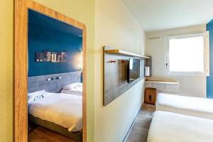 贝桑松贝桑松中心火车站宜必思快捷酒店 的小房间设有两张床和镜子