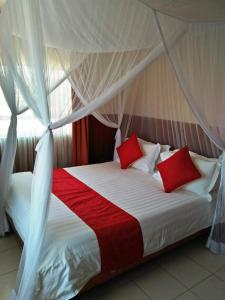 IsioloBomen Hotel的一张带红色和白色枕头的床