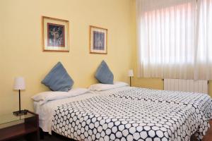 巴塞罗那贝哈尔旅馆的一间卧室配有一张带蓝色枕头的大床
