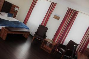 格尔梅斯海姆德姆斯彻蒙酒店的卧室配有一张床、一张桌子和椅子