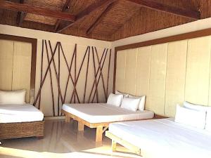 长滩岛Kaiyana Boracay Beach Resort的客房设有两张床和木制天花板。