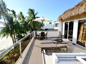 长滩岛Kaiyana Boracay Beach Resort的一个带桌椅的度假村阳台