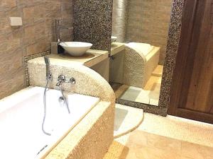 长滩岛Kaiyana Boracay Beach Resort的带浴缸、水槽和镜子的浴室