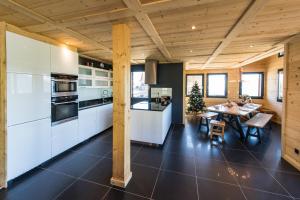 土绪尔Harfang des Neiges的厨房配有白色橱柜、餐桌和用餐室