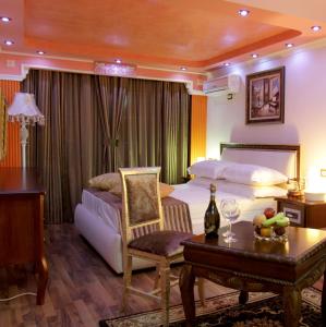 地拉那Hotel Villa Fernando Tirana的一间卧室配有一张床和一张桌子及椅子