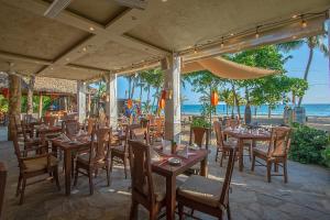 喀巴里特Hotel Villa Taina的海滩上的餐厅,配有桌椅