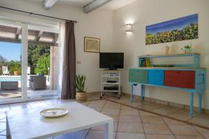卡萨拉诺Villa Majesi的客厅配有电视和桌子