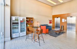 塞拉Go Inn Serra的餐厅设有配备了橙色椅子和冰箱的酒吧