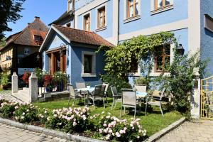 罗滕堡贝佐尔德酒店的庭院里带椅子和桌子的蓝色房子