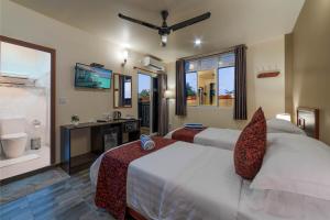 乌库拉斯Paguro Beach Inn的一间带两张床的卧室和一间带水槽的浴室