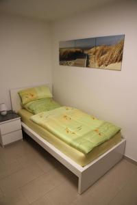 鲁尔河畔米尔海姆4realax的卧室内的一张床铺,墙上有绘画作品