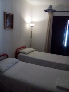 卡斯特布奥诺Casa Levante的配有两张床的带灯和窗户的客房