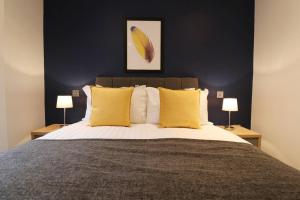 利兹Heart of Leeds City Centre Living - Sleeps 6的一间卧室配有一张带黄色枕头的大床