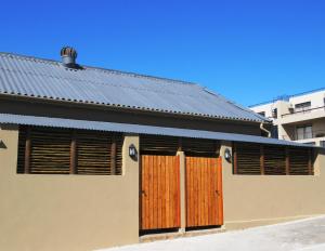 干斯拜Gansbaai Central Accommodation的木门和金属屋顶的房子