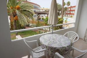 英格兰海滩厄瓜多尔公寓的阳台配有桌椅和遮阳伞。