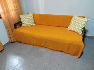 波萨达斯Departamento centrico en Posadas, garage opcional D4的一张橙色的床,上面有两个枕头
