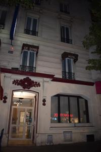 巴黎Hotel Puy De Dôme的白色的建筑,前面有标志
