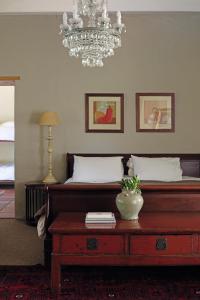 斯韦伦丹Joubertsdal Country Estate的一间卧室配有一张带桌子和吊灯的床。