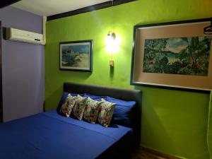 威廉斯塔德特拉克拉公寓的一间卧室配有一张蓝色的床和绿色的墙壁