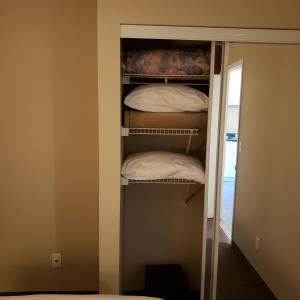 Deep RiverShemron Suites Hotel的配有白色枕头的衣柜