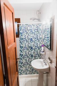 圣卡洛斯-德巴里洛切Hostel Olimpo House的一间带水槽和淋浴帘的浴室