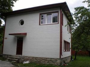 塔林Vabriku Guesthouse的一间白色的小房子,有窗户和门