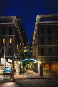 松山多格酒店的一条城市街道,晚上有两栋高大的建筑
