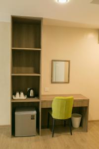 玻璃市港口Savana Hotel & Serviced Apartments的一张带黄色椅子和镜子的桌子
