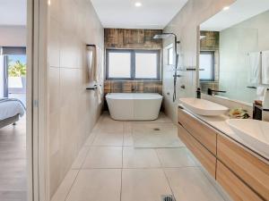 凯恩斯Superior Luxury Apartment in the City的浴室配有两个盥洗盆和浴缸。