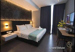 新山Solid Hotels的酒店客房设有一张大床和一张书桌。