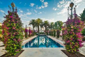 苏提万Hotel Lemongarden - Adults Only的一座种有粉红色花卉和棕榈树的游泳池