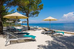 苏提万Hotel Lemongarden - Adults Only的海滩上的一组椅子和遮阳伞
