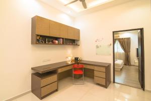 Kampong ManggisLanded Cozy House Near SPICE, Airport的一个带书桌和红色凳子的家庭办公室
