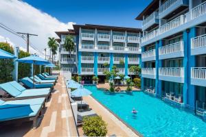奥南海滩Blue Tara Hotel Krabi Ao Nang的一张酒店图画,里面设有游泳池和遮阳伞