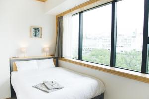 大阪Hotel Noum OSAKA的一间卧室设有一张床和一个大窗户