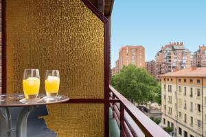 洛格罗尼奥San Pietro Home La Rioja的阳台上的桌子上放两杯橙汁