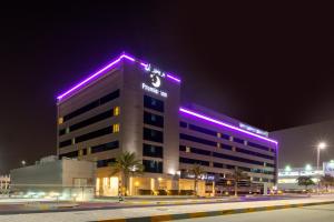 阿布扎比Premier Inn Abu Dhabi Airport Business Park的上面有紫色灯的建筑