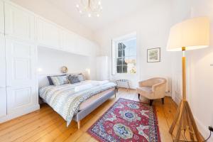 布里斯托Elegant Period Clifton Balcony Apt - Simply Check In的一间卧室配有床、灯和地毯