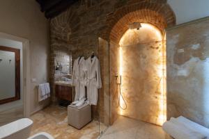 佛罗伦萨Donati Luxury Tower Suites的带淋浴的浴室和石墙