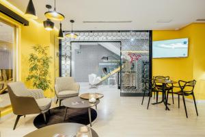 穆尔西亚Hotel Cetina Murcia的餐厅拥有黄色的墙壁和桌椅