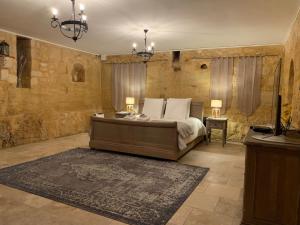 多姆Maison de la Combe的一间卧室配有一张带两盏灯和地毯的床。