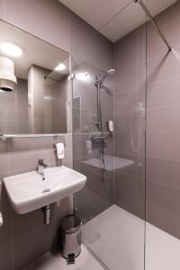 俄斯特拉发协和俱乐部酒店的一间带水槽和玻璃淋浴的浴室