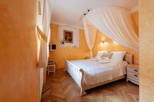捷克克鲁姆洛夫罗曼蒂克精品酒店的一间卧室配有一张带白色床单和窗帘的床